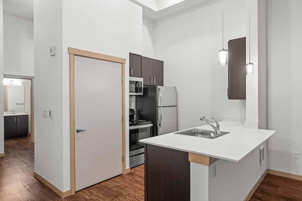 A kitchen with a white counter top and brown cabinets.