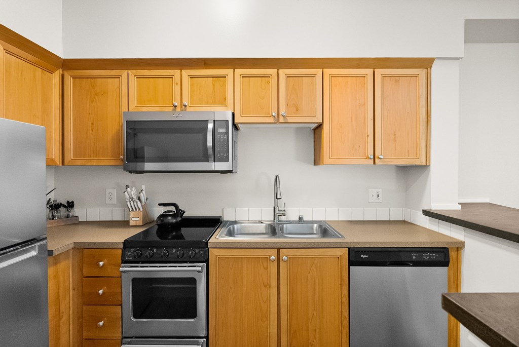 A kitchen with wooden cabinets and stainless steel appliances.