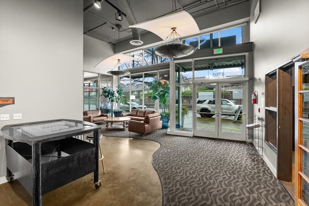 A modern office space with a glass wall and a car displayed outside.