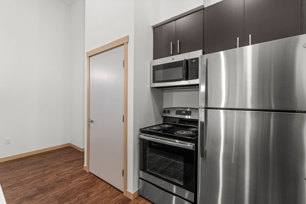 A kitchen with a stainless steel refrigerator, oven, and microwave.