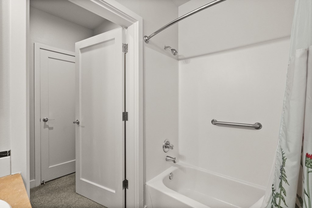 A white bathroom with a tub and shower.