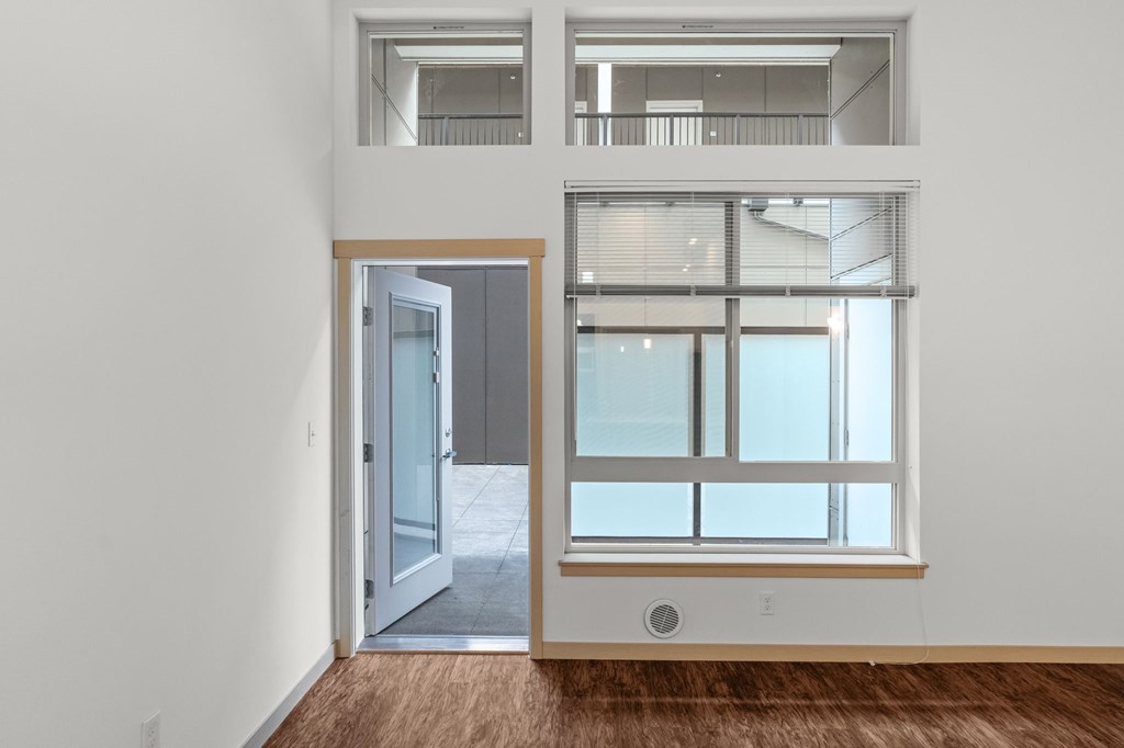 A room with a window and a door leading to another room.