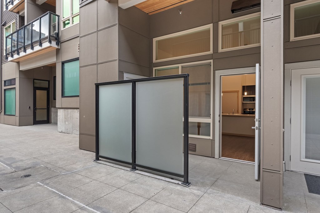 A modern building with a glass door and a balcony.