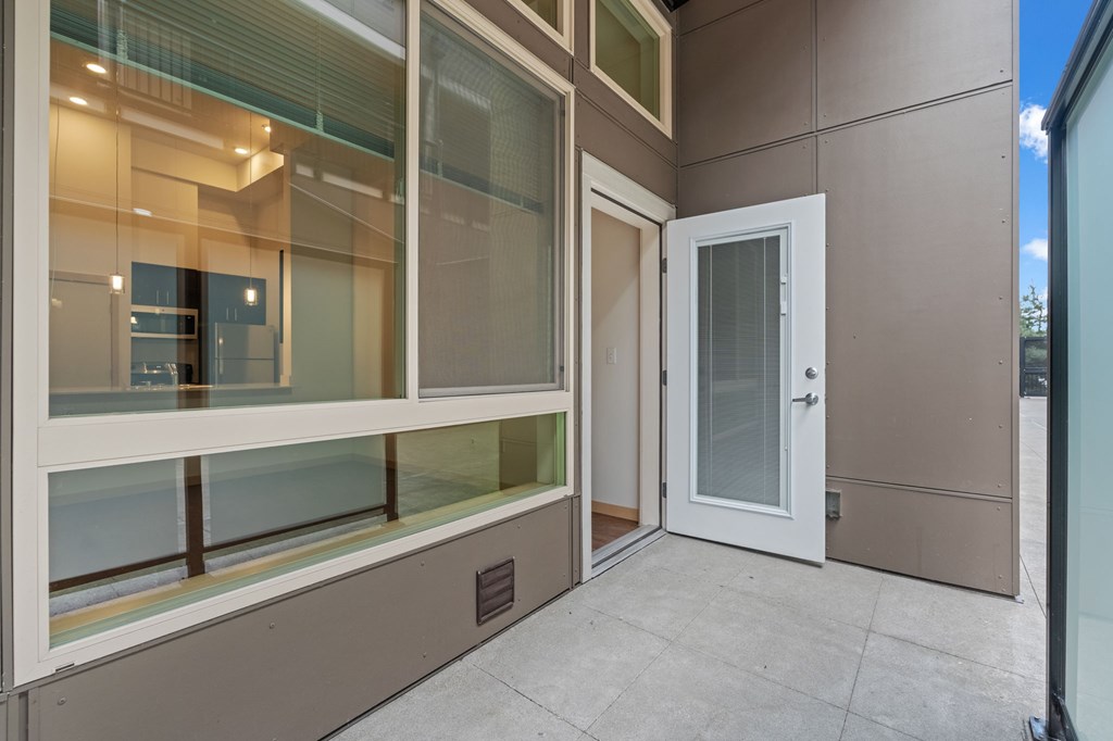 A white door is on the right side of a glass wall.