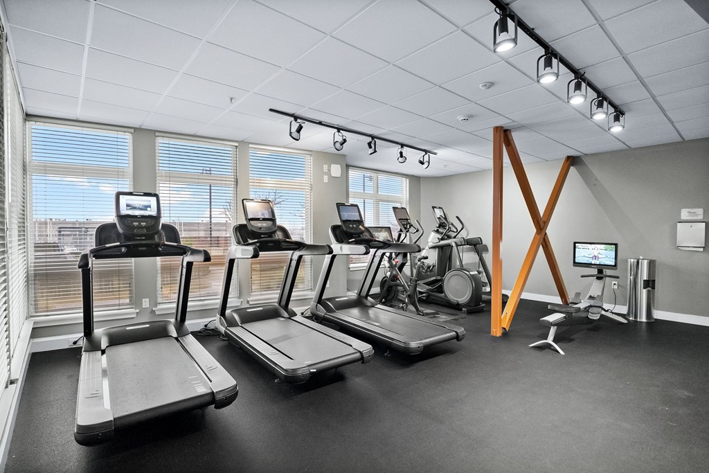 A gym with treadmills, elliptical machines, and other exercise equipment.
