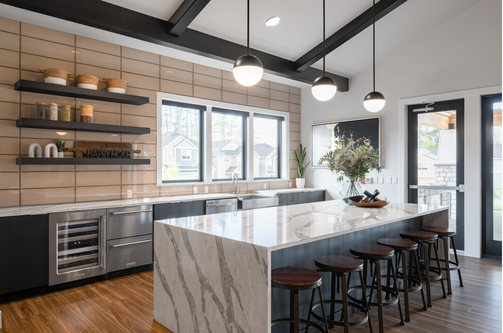 a large kitchen with a marble counter top and bar stools