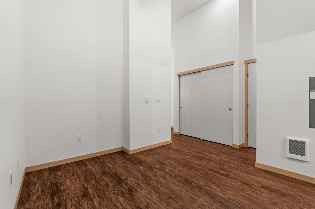 A room with wooden flooring and white walls.