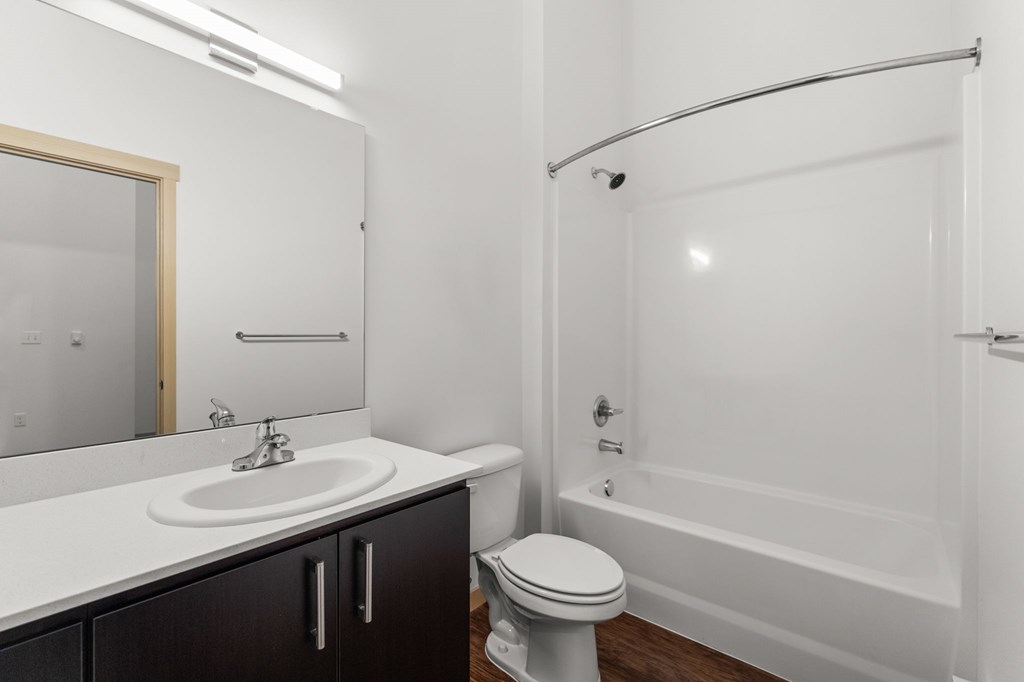 A white bathroom with a toilet, sink, and bathtub.