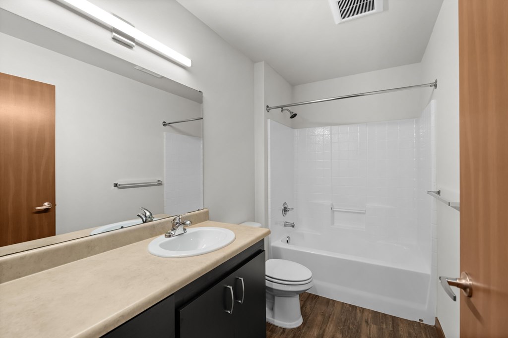 A bathroom with a sink, toilet, and bathtub.