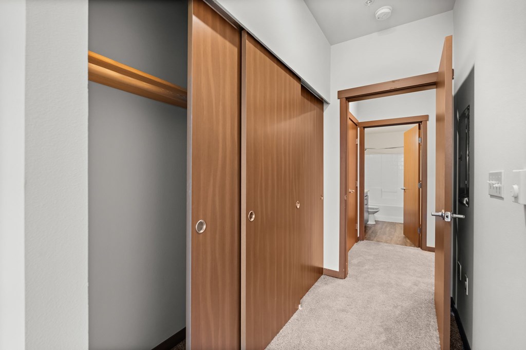 A hallway with two doors on the left and one on the right.