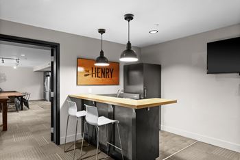 A modern office space with a bar area and a sign that reads "The Henry".