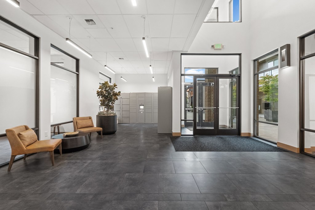 A modern office lobby with a black floor and wooden furniture.