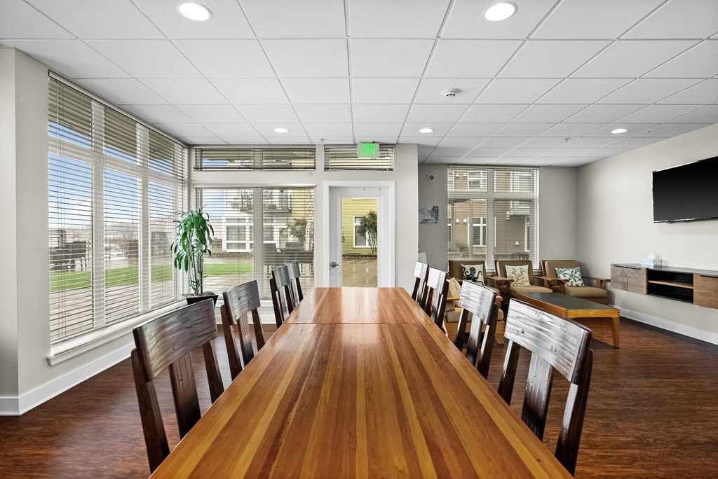 A conference room with a long table and chairs.