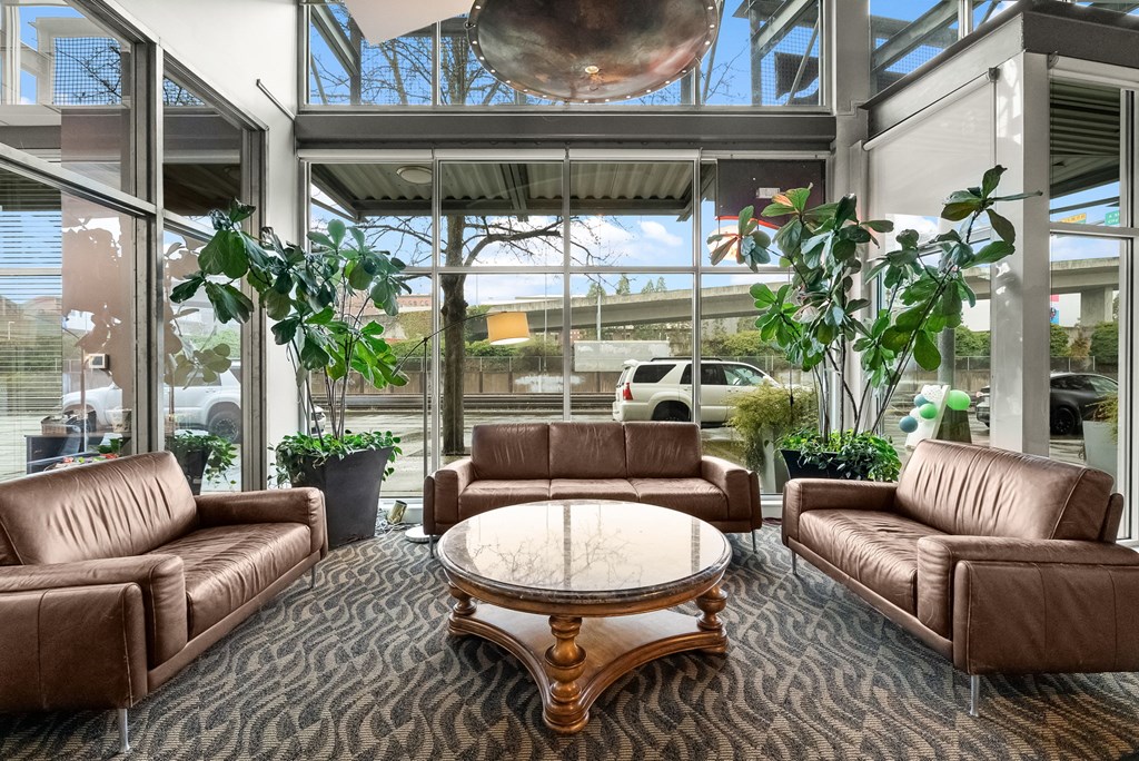 A large brown leather couch sits in a room with a glass ceiling.