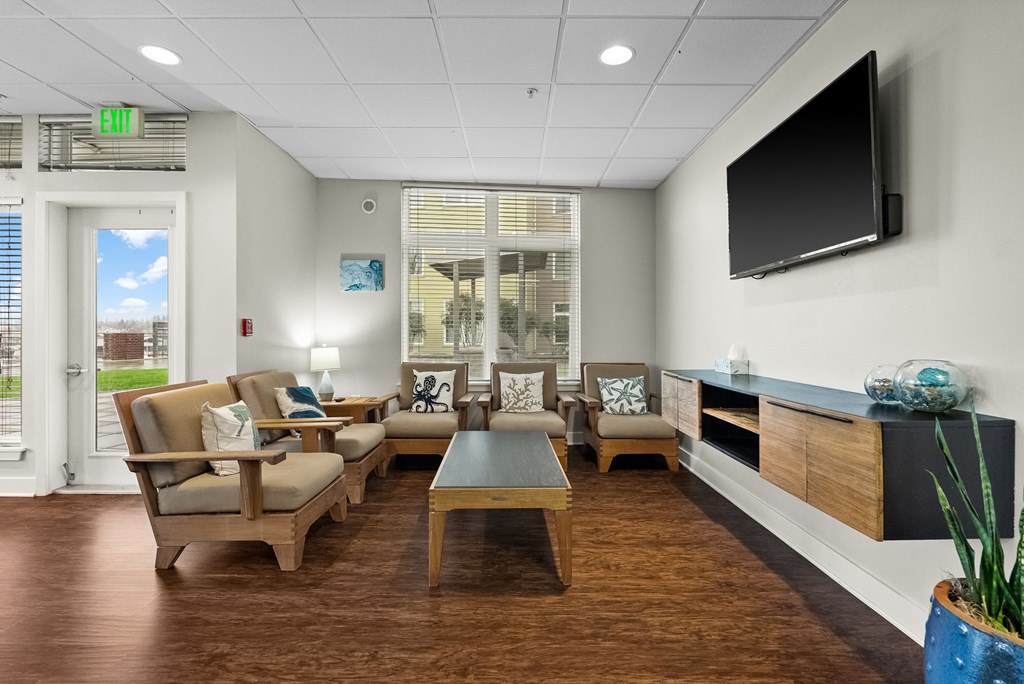 A living room with a couch, chairs, and a television.