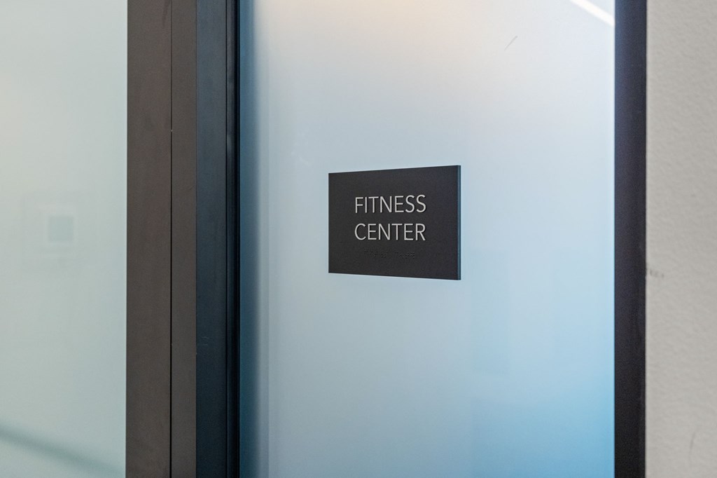 A sign on a glass door reads "Fitness Center".