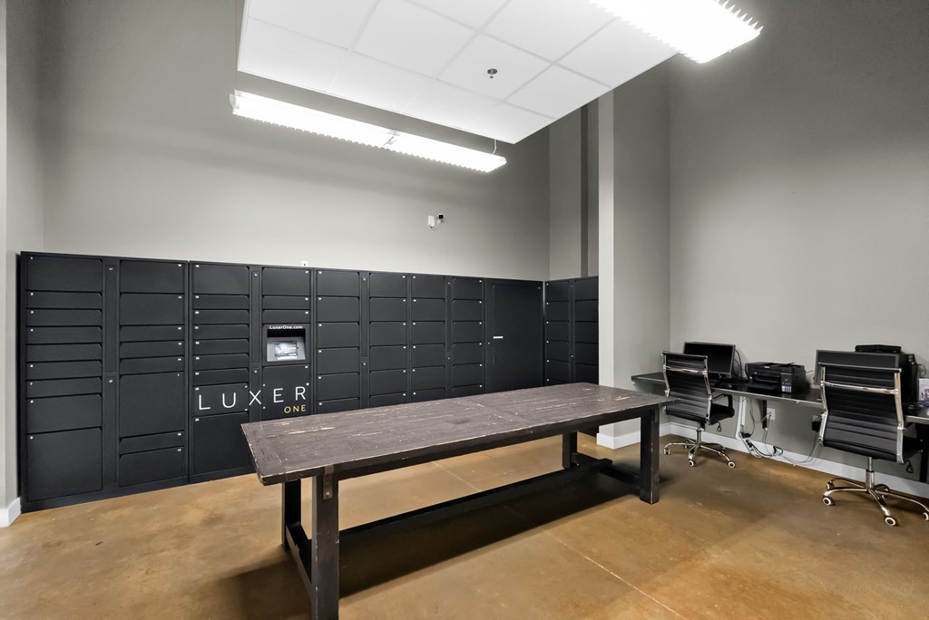 A room with a LUXE sign on the wall and a table with chairs.