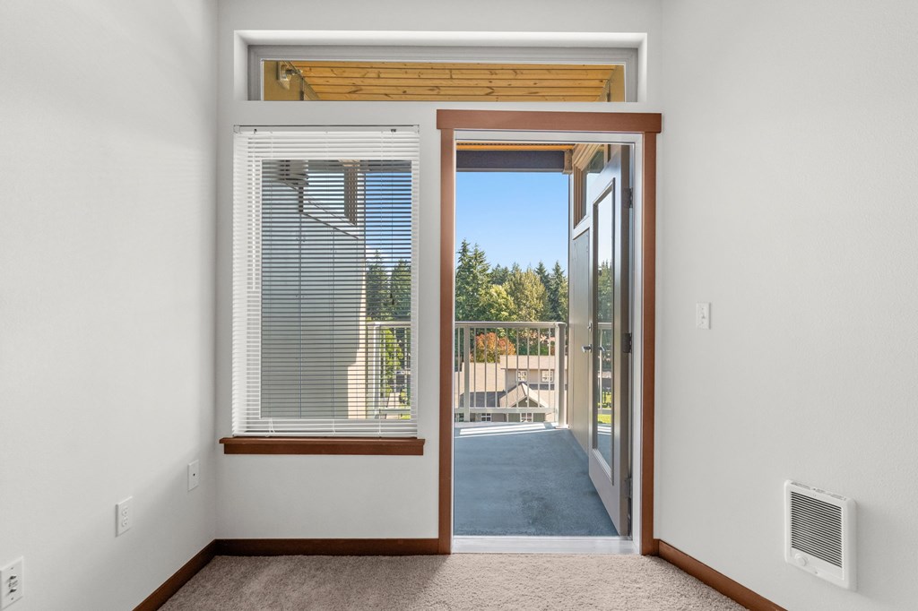 A room with a sliding glass door leading to a balcony.