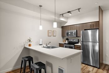 A modern kitchen with a stainless steel refrigerator and a white countertop.