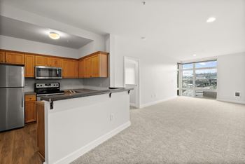 A kitchen with wooden cabinets and a stainless steel refrigerator.