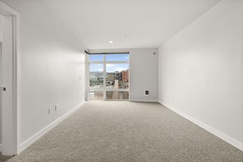A large empty room with a window overlooking a cityscape.