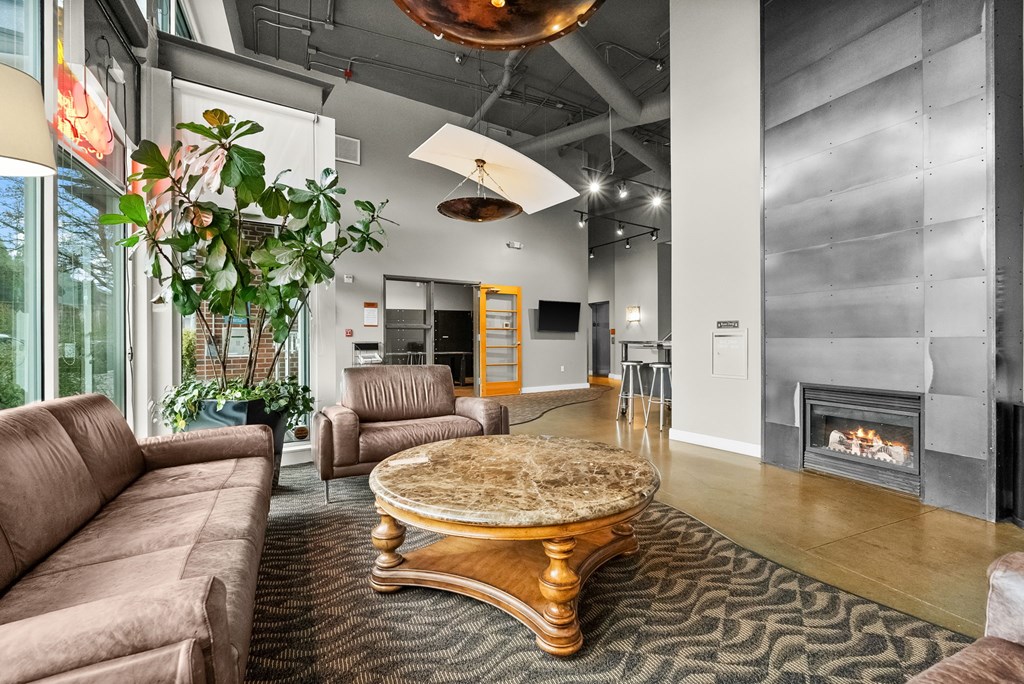 A living room with a brown couch and a fireplace.