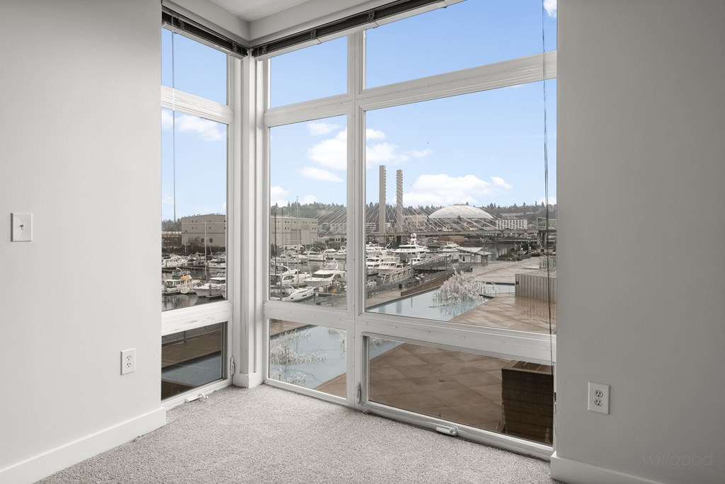 A room with a view of a marina and buildings outside.