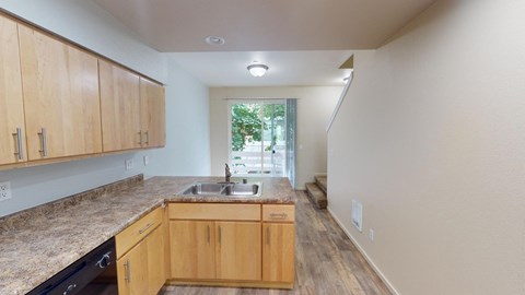 an empty kitchen with wooden cabinets and a sink