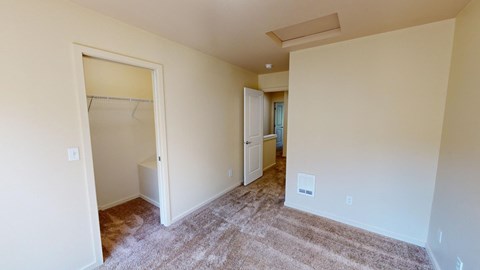 a bedroom with a closet and a hallway to a bathroom