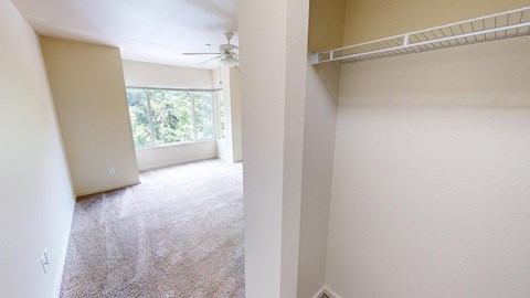 an empty living room with a ceiling fan and a window