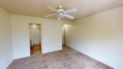 a empty living room with a ceiling fan