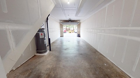 the inside of a garage with white walls and a concrete floor