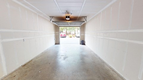 the inside of a garage with white walls and a concrete floor