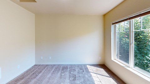 an empty room with large windows and carpet