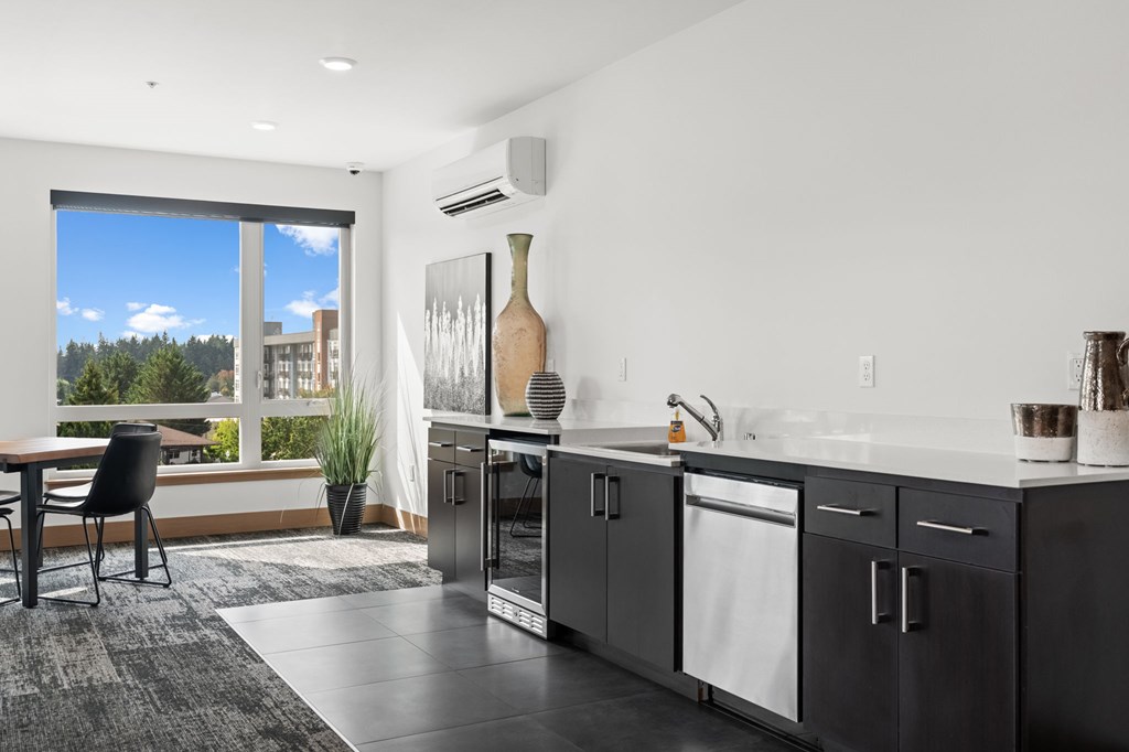 A modern kitchen with a view of the outdoors through a sliding glass door.