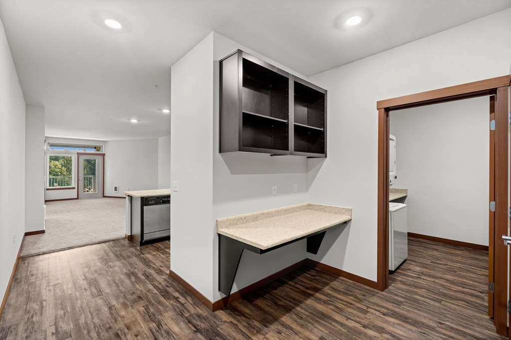 A kitchen with a wooden floor and white walls.