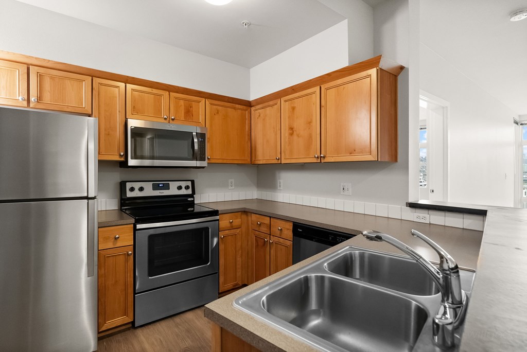 A kitchen with wooden cabinets and stainless steel appliances.