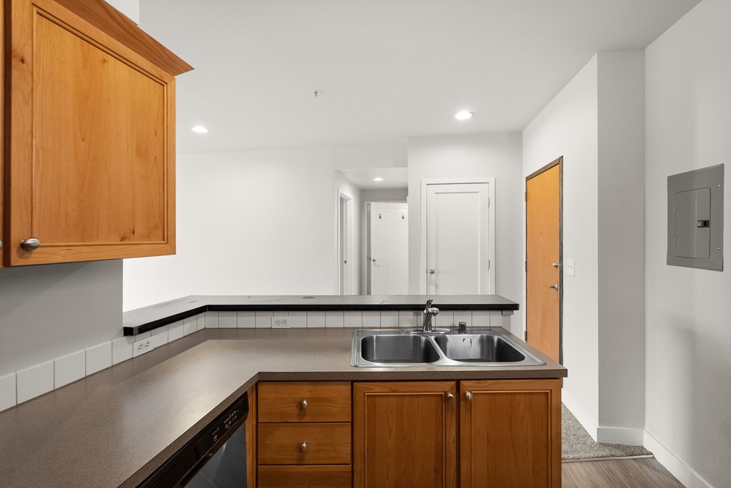 A kitchen with wooden cabinets and a stainless steel sink.