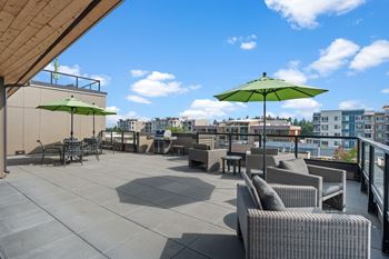 A patio with grey furniture and green umbrellas.