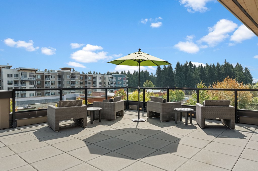 A patio with a table and chairs and an umbrella.