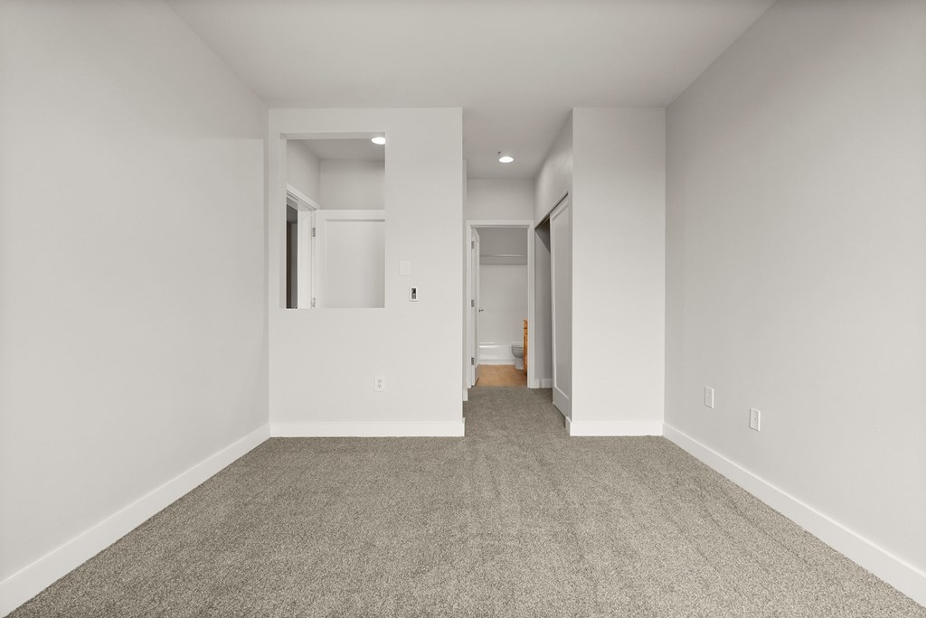 A long hallway with carpeted floors and white walls.
