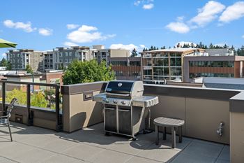 A patio with a grill and a table.