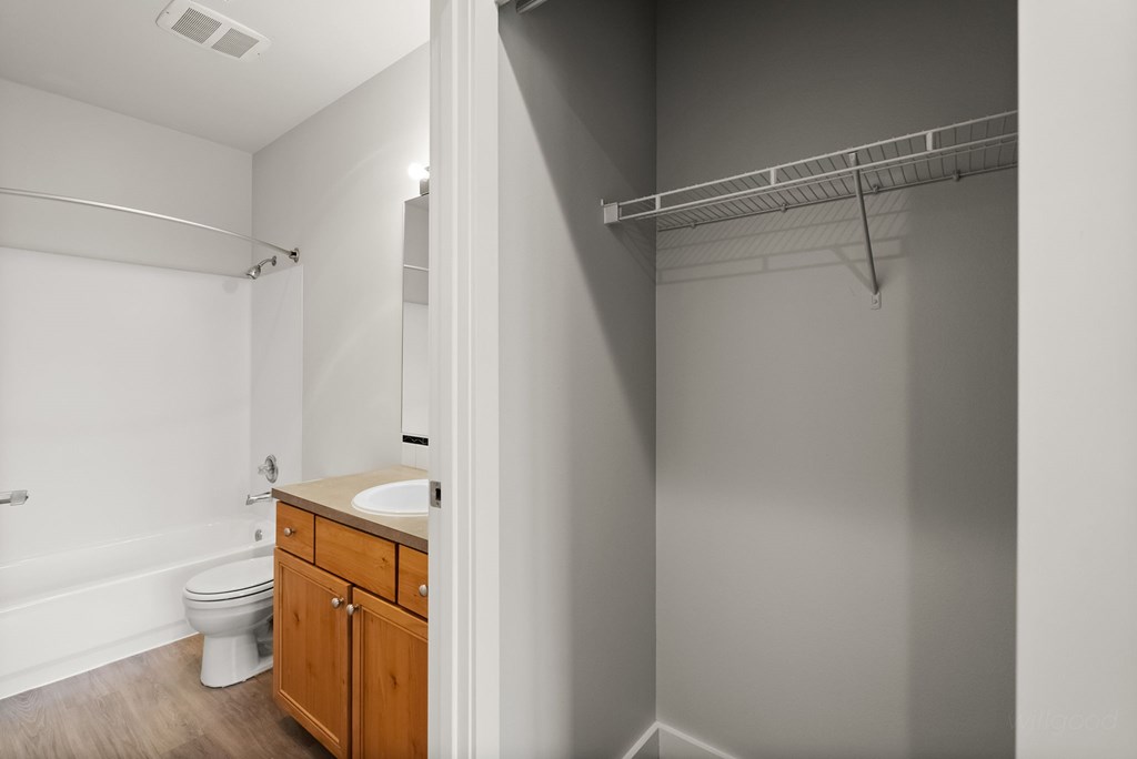 A bathroom with a toilet, sink, and a shelf.