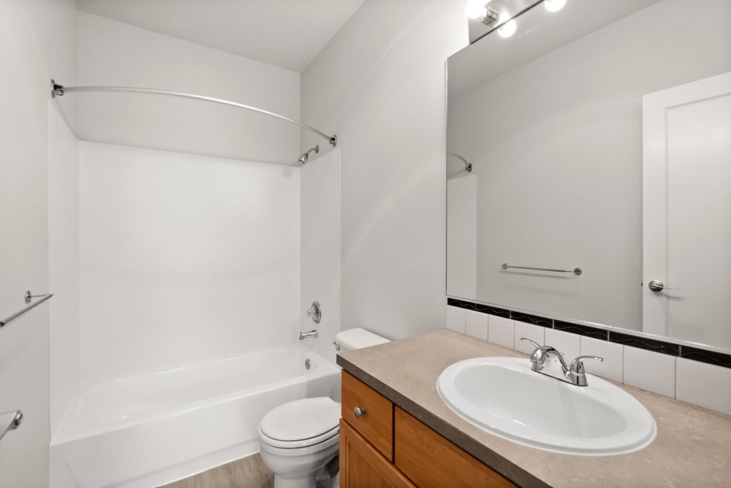 A white bathroom with a toilet, sink, and bathtub.