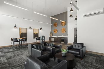 A black leather couch and chair set in a room with a coffee table.