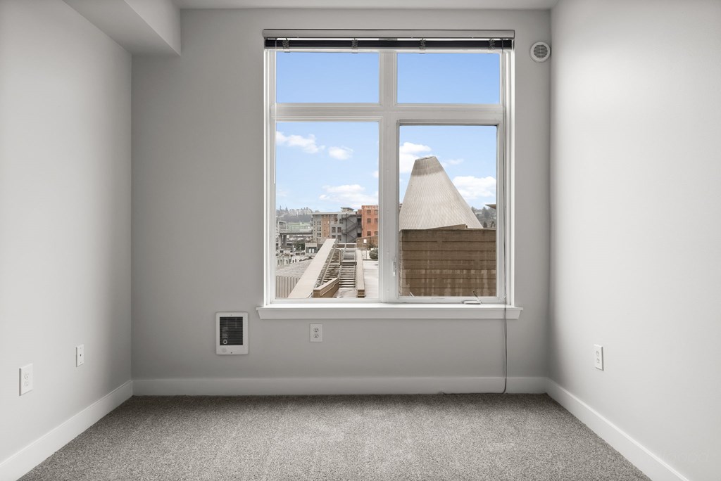 A room with a large window overlooking a city street.