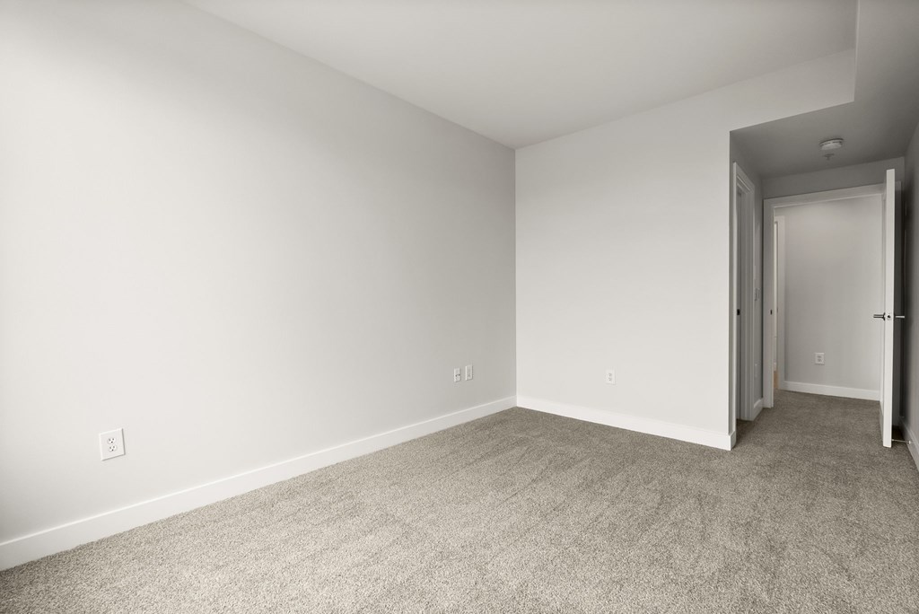 A room with a carpeted floor and white walls.