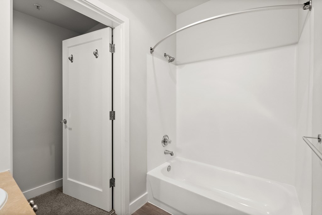 A white bathroom with a bathtub and a shower stall.