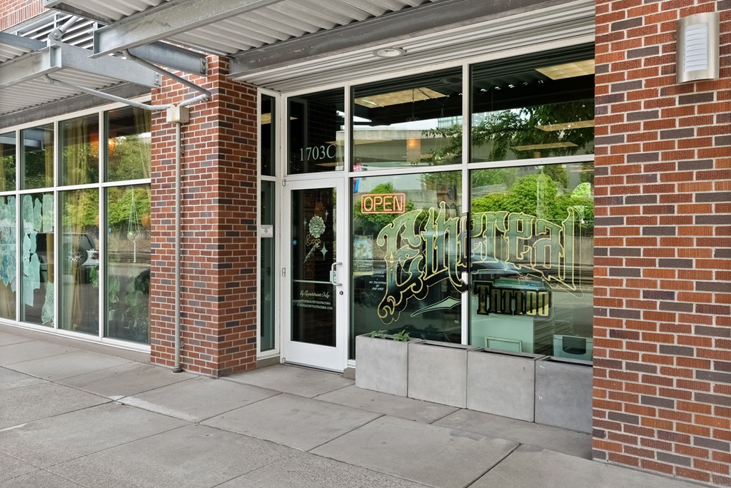 A storefront with a glass door and a neon sign that says "OPEN".