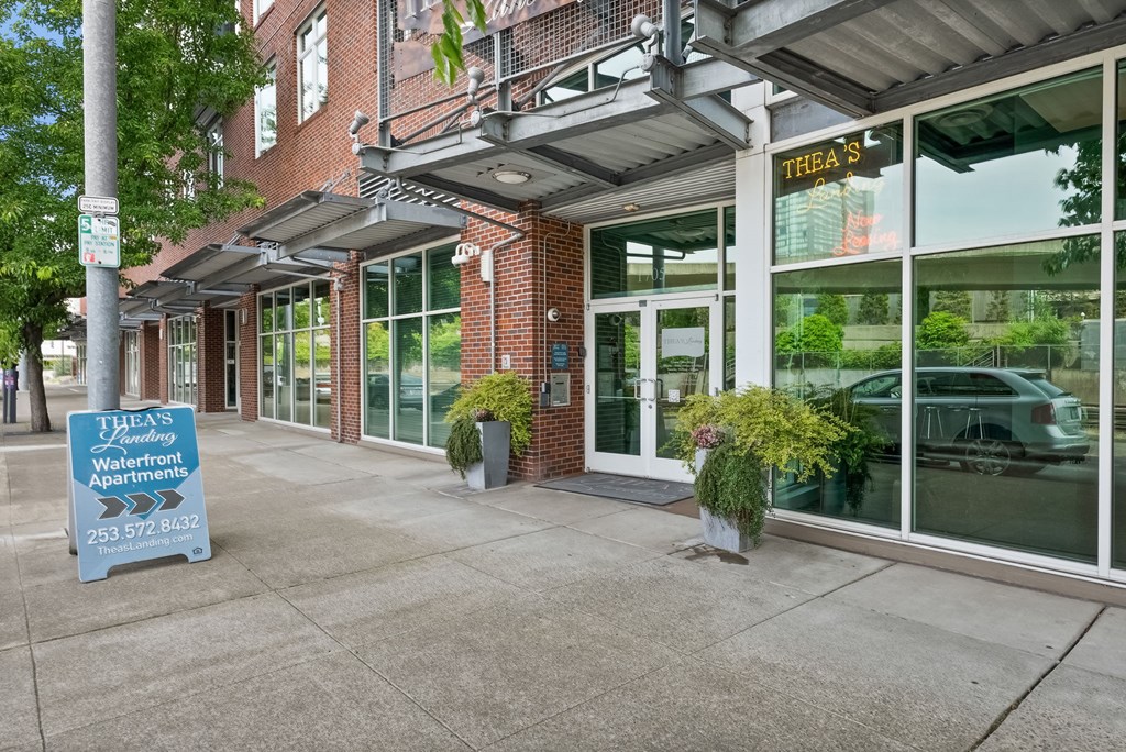 The front of a building with a sign that says "Thea's Friday Apartments".